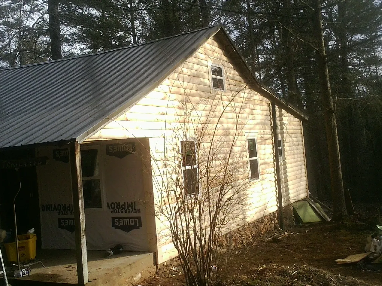 Log siding gable end under a dark metal roof edge in Hesperia