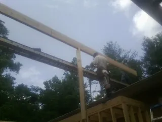 Carpenter setting a ridge beam over a new addition frame — Ice Dam Removal by Roofing Brothers in Hesperia