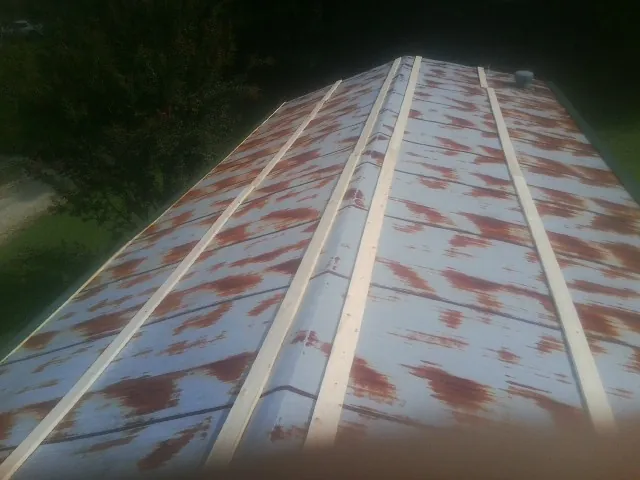 Rusted metal roof panels with new wood purlins before replacement — Storm Damage Roof Repair in Hesperia by Roofing Brothers