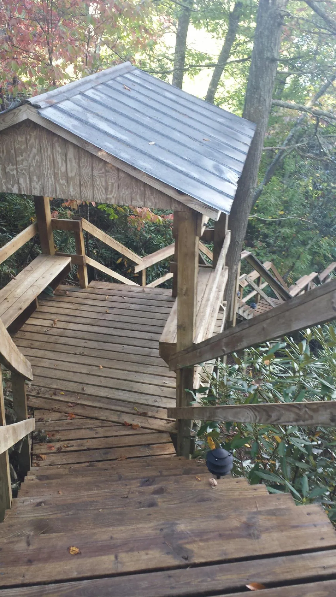 Metal roofed shelter over wooden steps on a wooded walkway — Skylight Repair & Installation work by our crew in Hesperia